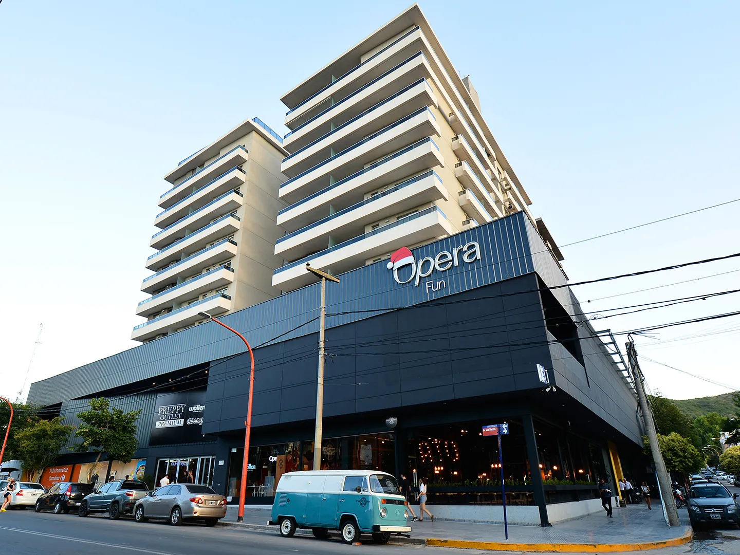 The Opera Fun mall seen from the corner of Av. San Martín, with its dark façade and sign below the apartment tower — Fun sobre Hielo (Opera Fun)