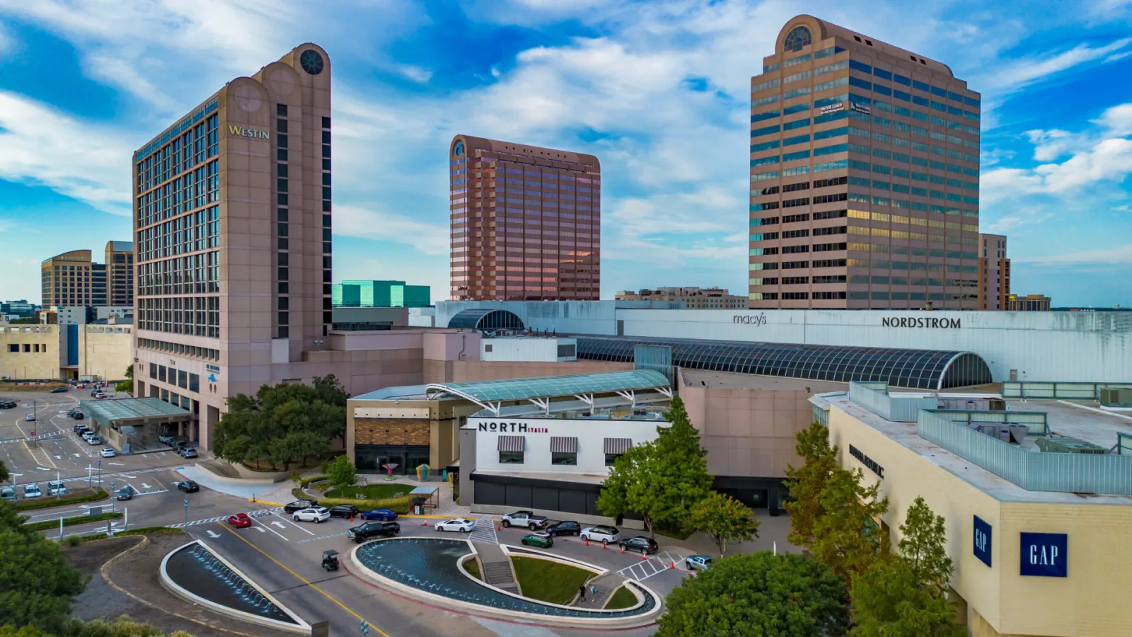 Galleria Dallas desde arriba en 2025: el largo techo de bóveda de cañón de vidrio que cubre la pista se extiende entre la torre Westin y las alas de Macy's y Nordstrom. — Galleria Dallas Ice Skating Center