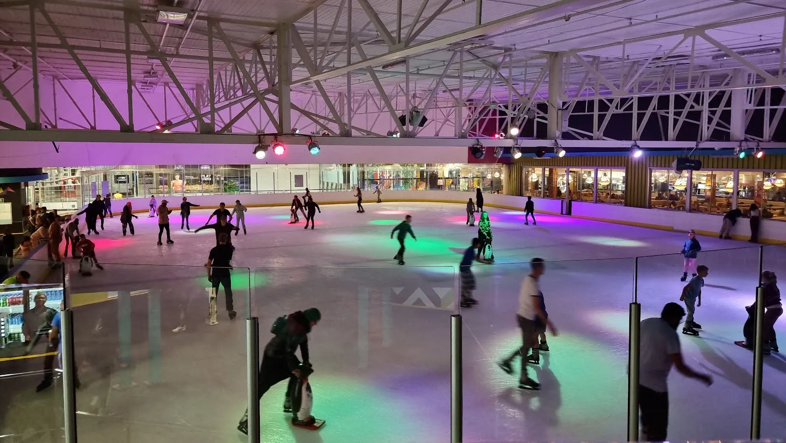 The Galleria Ice Rink ice sheet with a crowd of skaters under the coloured lights — Galleria Mall Ice Rink