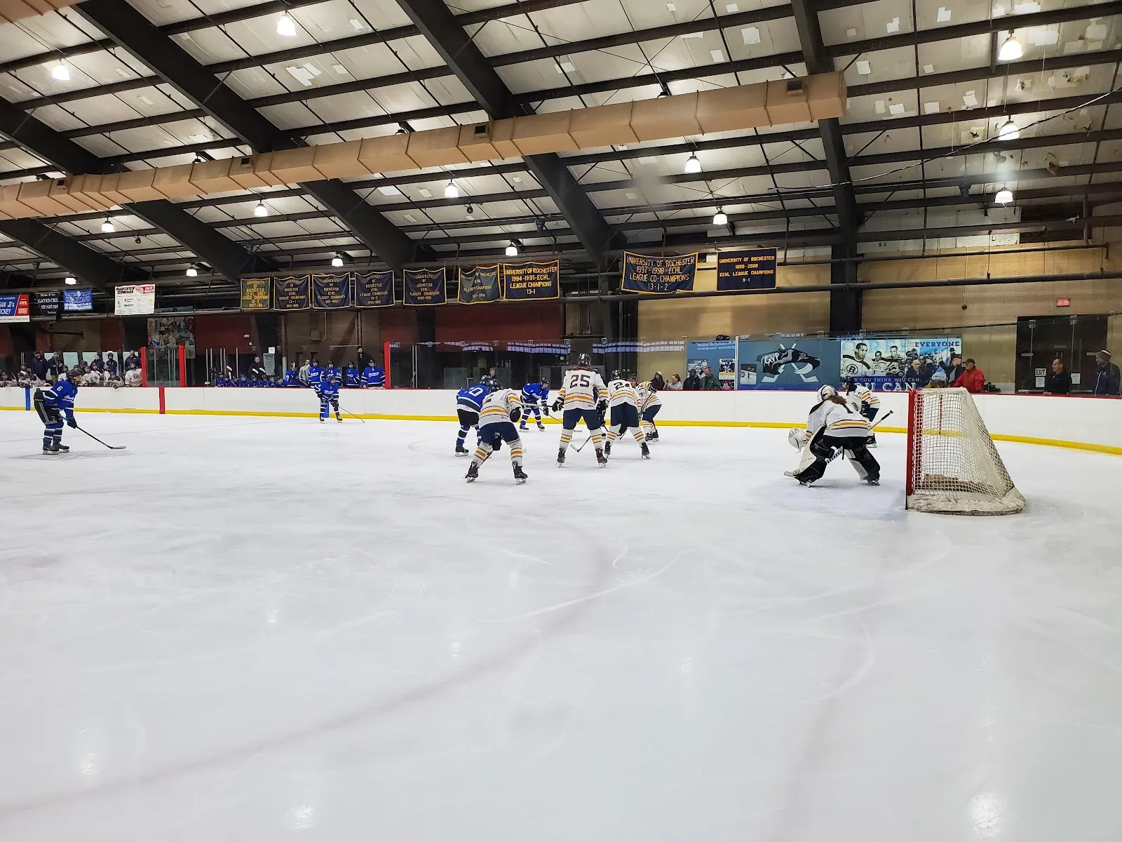 A hockey game on the Genesee Valley ice, players at a distance — Genesee Valley Ice Rink