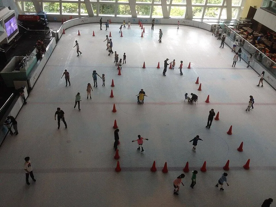 The Glacier ice sheet seen from a gallery above, with training cones across the surface and skaters at a distance (2015). — Glacier (Festival Walk)