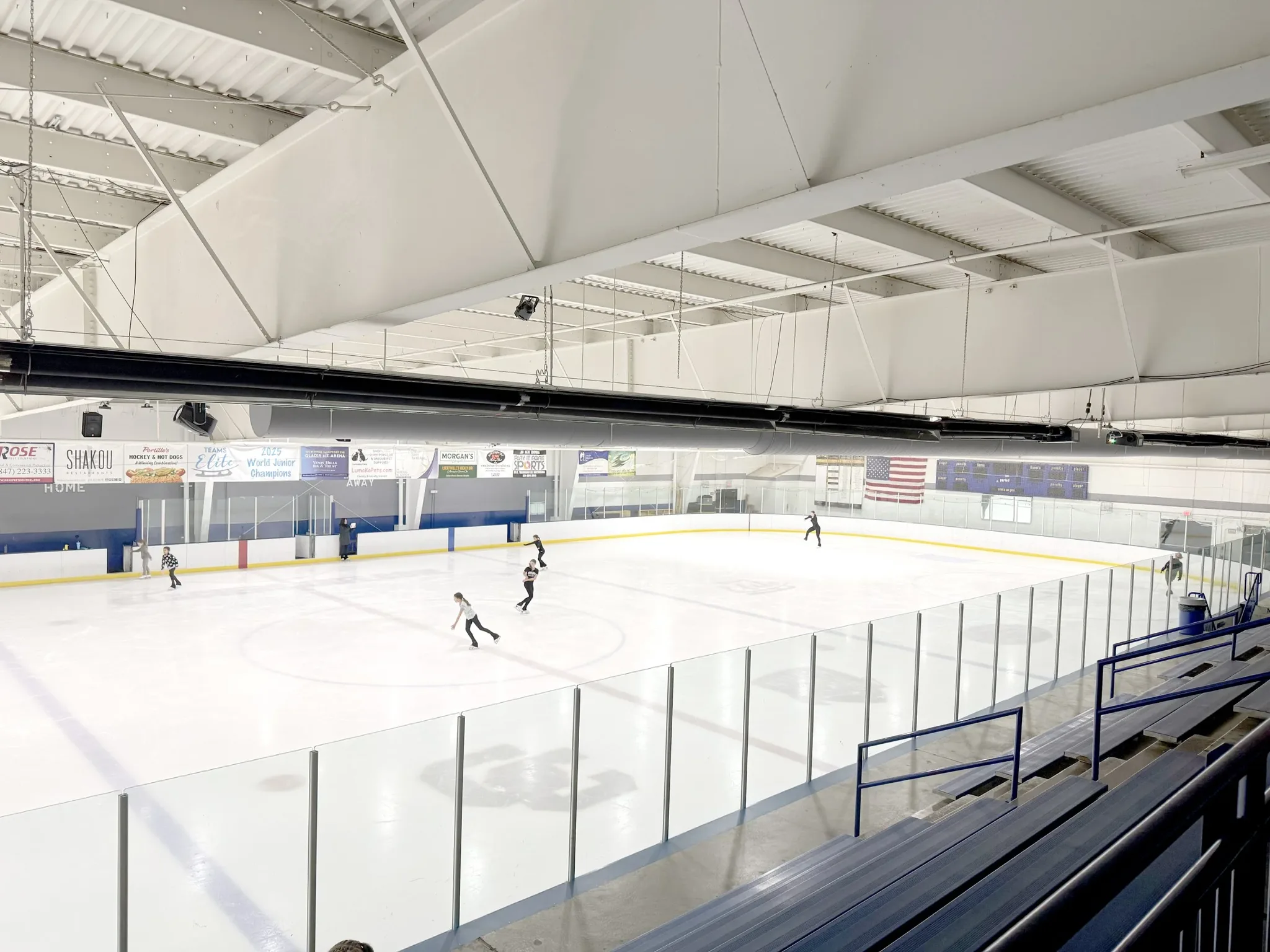 Skaters spread down the sheet, bleachers in the foreground — Glacier Ice Arena (Vernon Hills)