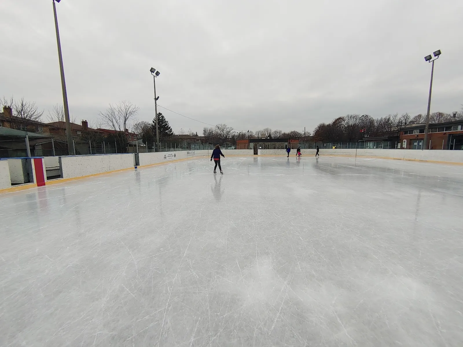 Vista amplia del hielo de la pista al aire libre de Glen Long bajo los reflectores, con un patinador a lo lejos — Glen Long Community Centre Outdoor Ice Rink