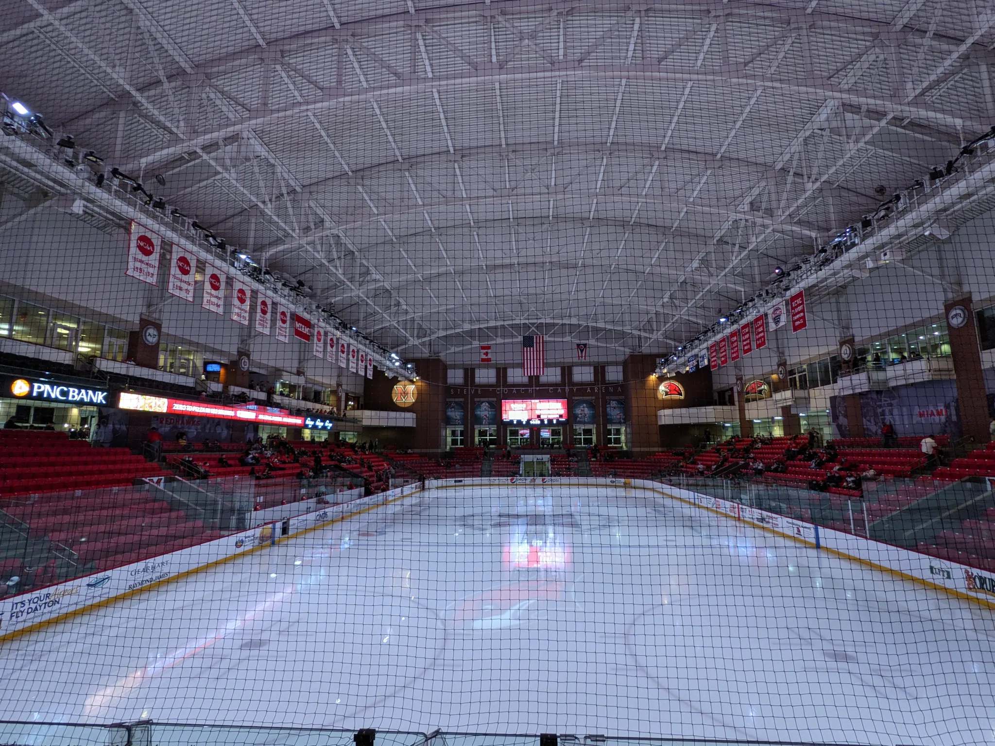 Whole ice sheet of Steve Cady Arena seen end-on from behind the goal netting — Goggin Ice Center
