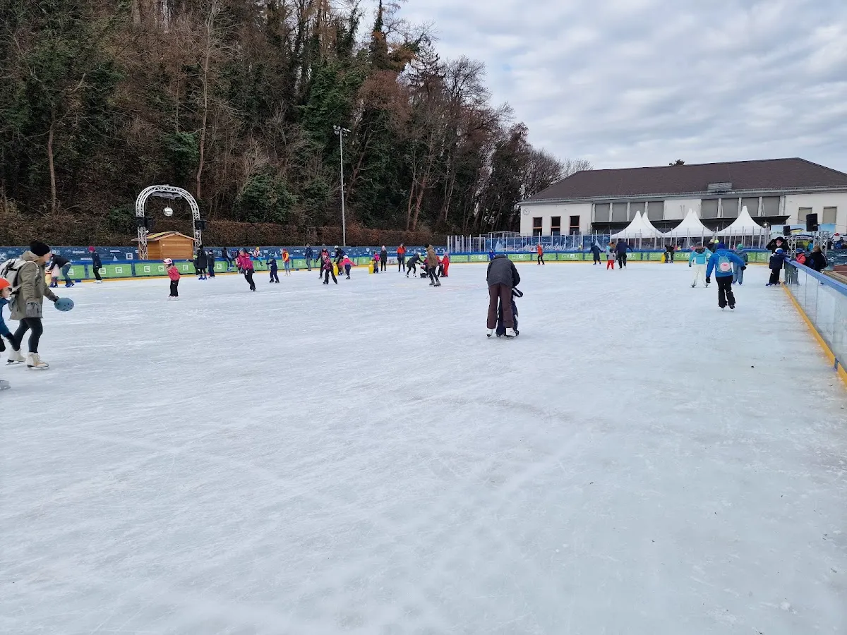 The open-air ice of the Grazer Winterwelt with skaters and the pavilion behind — Grazer Winterwelt