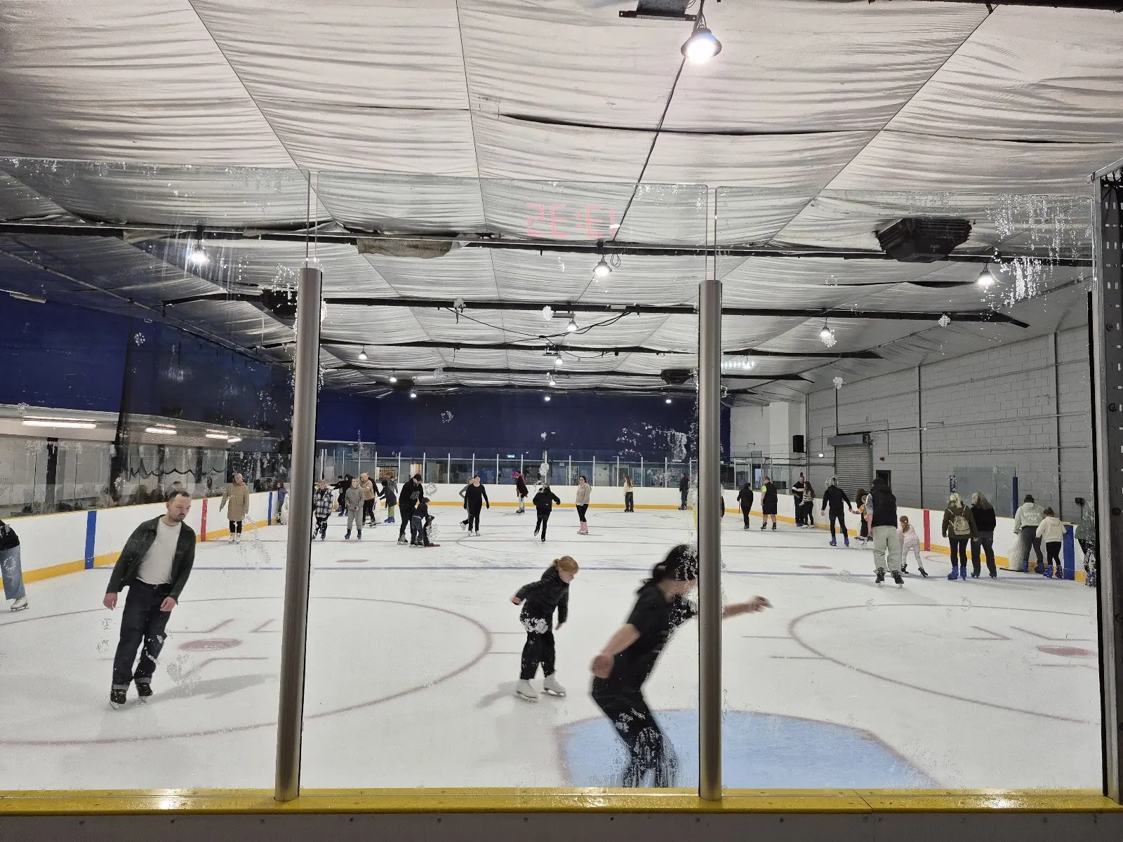 Skaters on the ice at Grimsby Ice Rink, seen through the rink glass — Grimsby Ice Rink