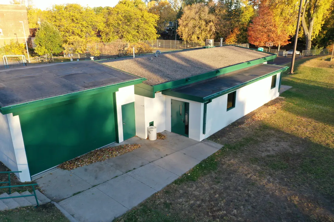 The green and white warming house beside the Groveland rinks, seen from above in autumn — Groveland Park Outdoor Rinks