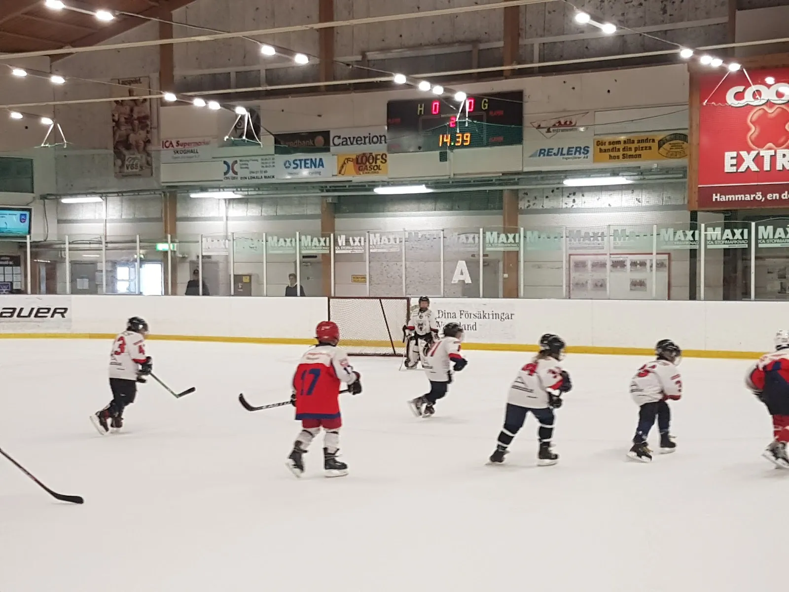 Unga hockeyspelare som åker på isen i Hammarö ishall framför sponsorsargerna – Hammarö ishall