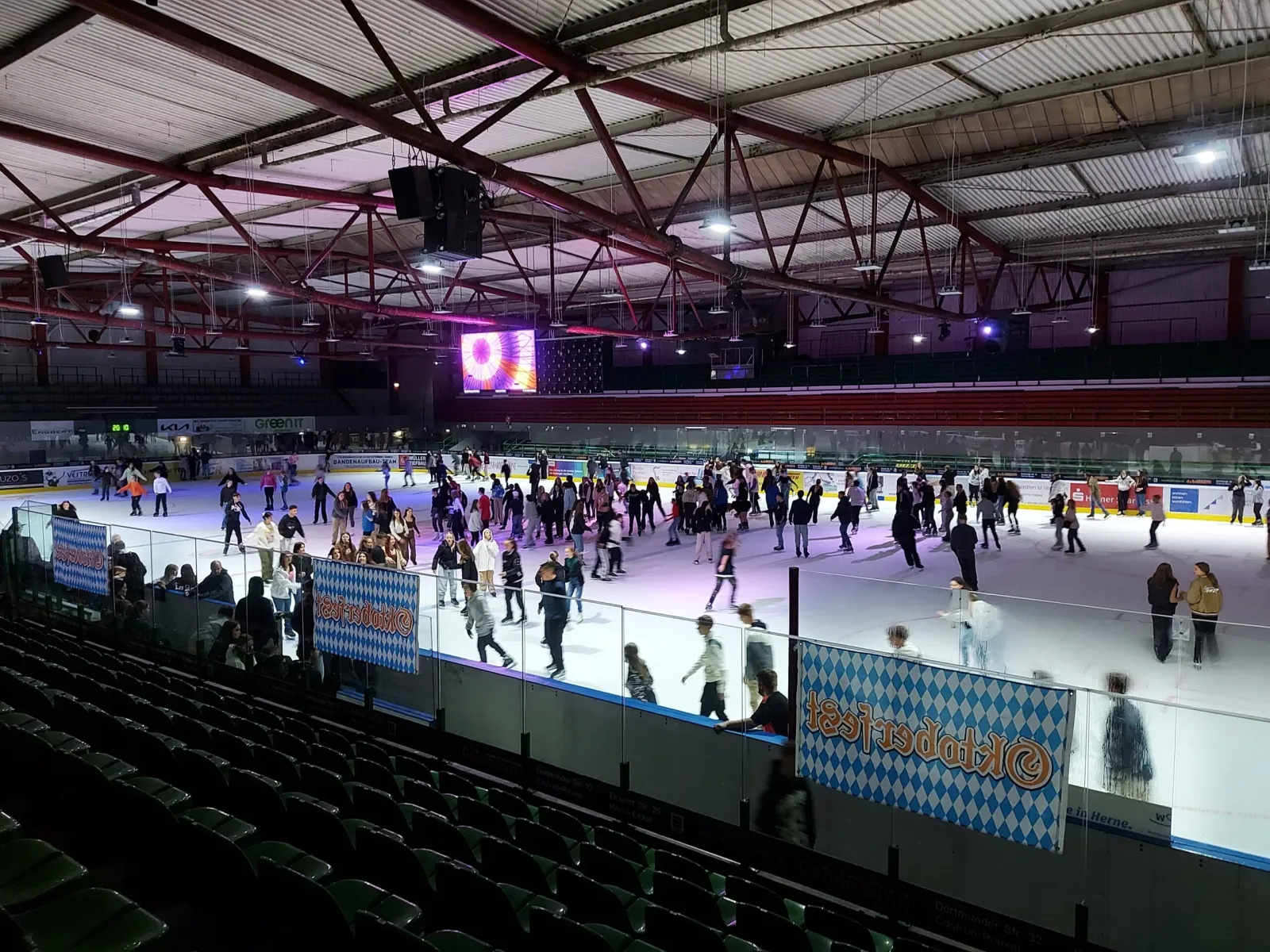A public skating night at the Hannibal Arena, skaters moving across the lit ice under the dark steel roof. — Hannibal-Arena