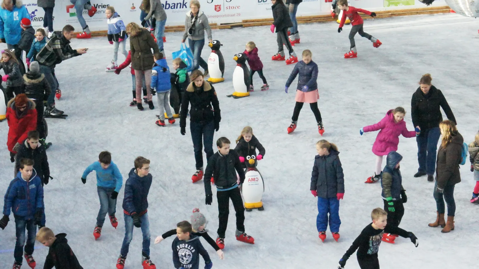 Schaatsers en pinguïnschaatshulpen op het ijs van Harderwijk op IJs – Harderwijk op IJs