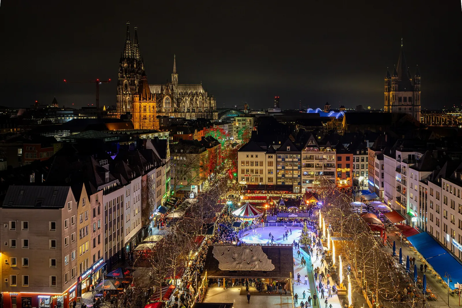 The Heumarkt Christmas market and its rink seen from above at night with Cologne Cathedral behind. — Heinzels Wintermärchen Eisbahn
