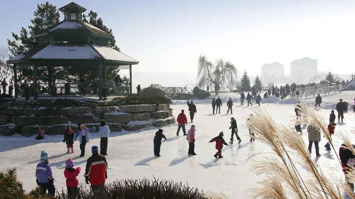Patinadores en la pista del estanque de Heritage Park en Barrie en invierno, con un cenador detrás del hielo. — Heritage Park Pond Rink (Barrie)
