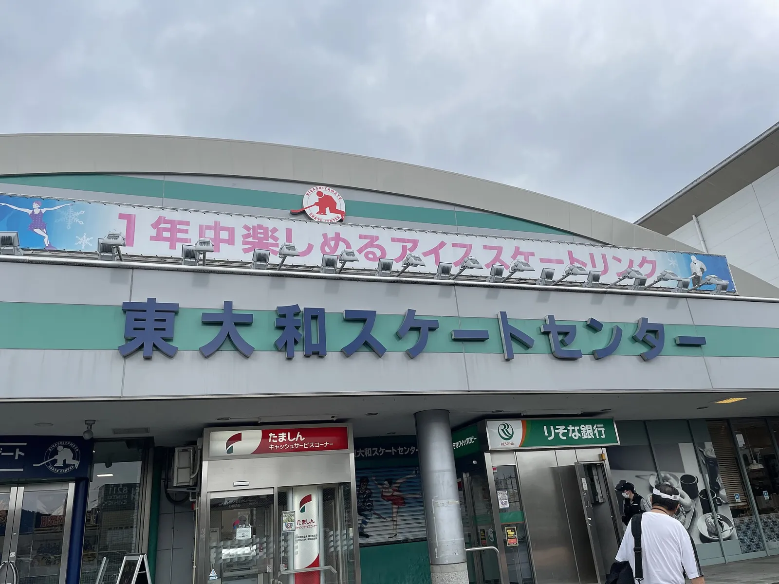 The arched front of the Higashiyamato Skate Center beside Higashiyamato-shi station, with the rink's name across the entrance — Higashiyamato Skate Center