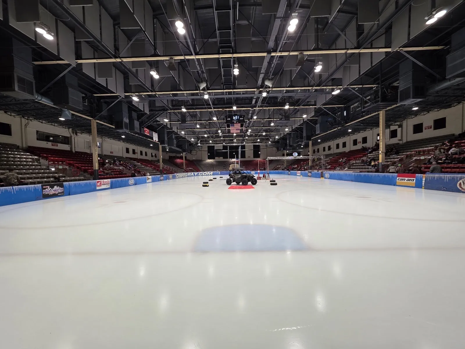 The Hobart Arena ice at floor level, set up for an ice-racing event, with the red seating bowl and steel roof trusses around it — Hobart Arena