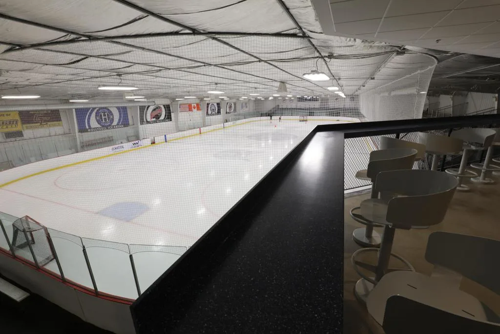 Nearly the whole sheet seen from an elevated bar rail above one corner — Hollydell Ice Arena