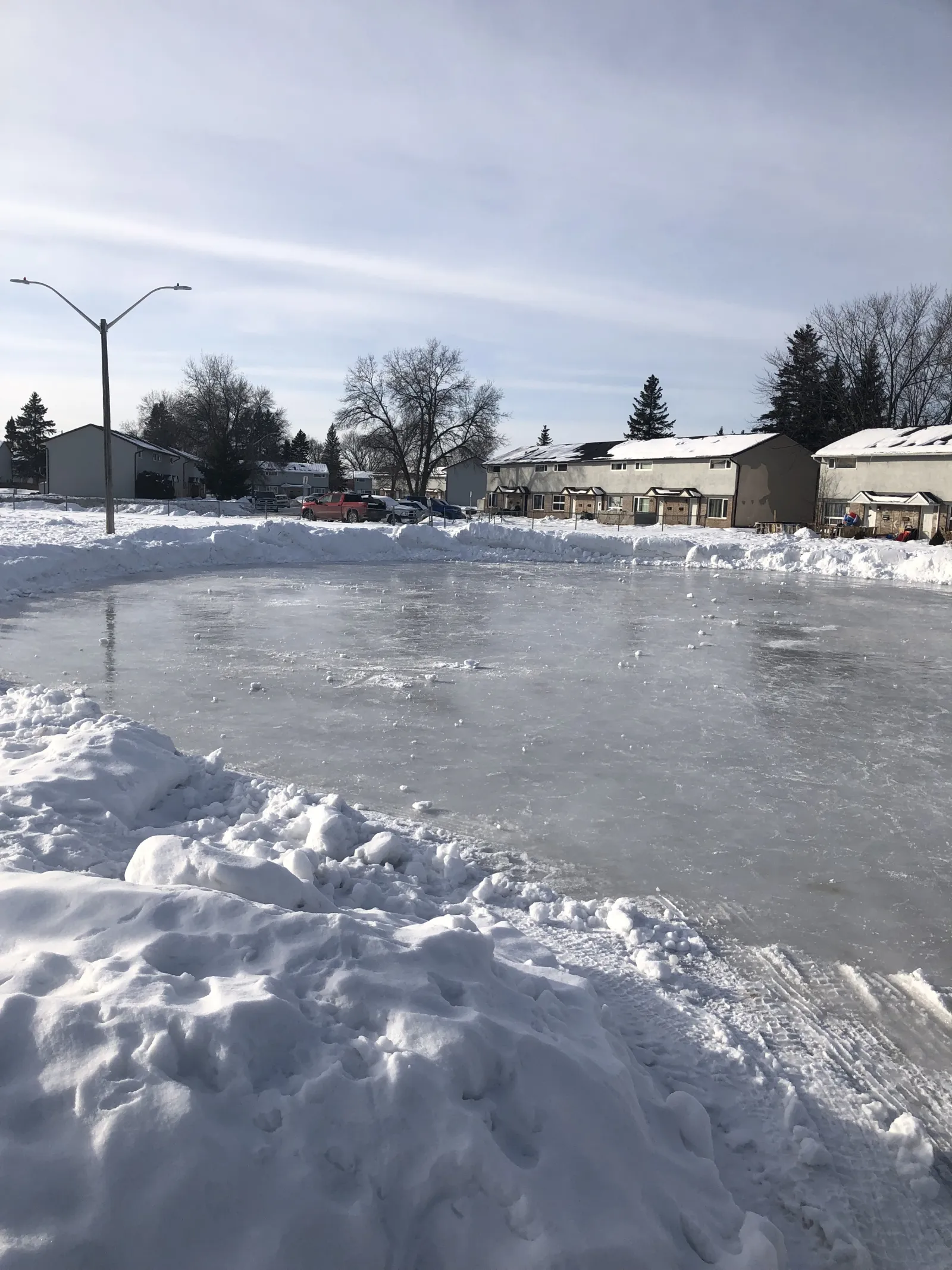The Holt Parkette pond with a street light and houses beyond — Holt Parkette Skating Pond