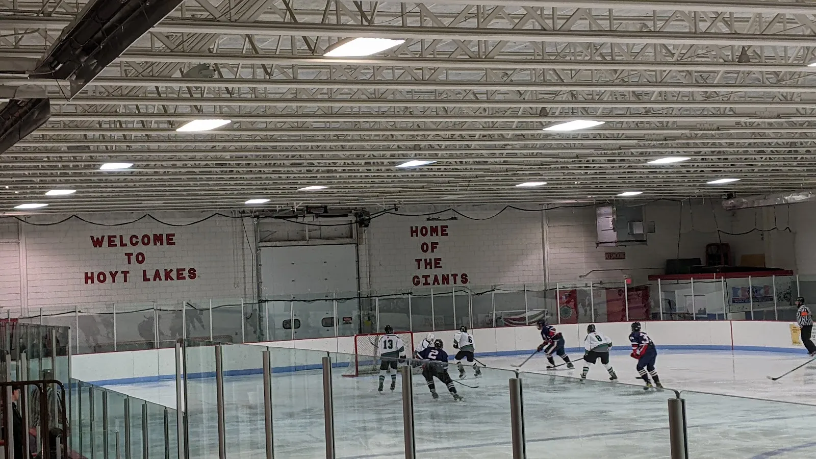 Un partido sobre el hielo en el Hoyt Lakes Arena bajo la pancarta Welcome to Hoyt Lakes, Home of the Giants (foto de la ficha de Google Maps) — Hoyt Lakes Arena