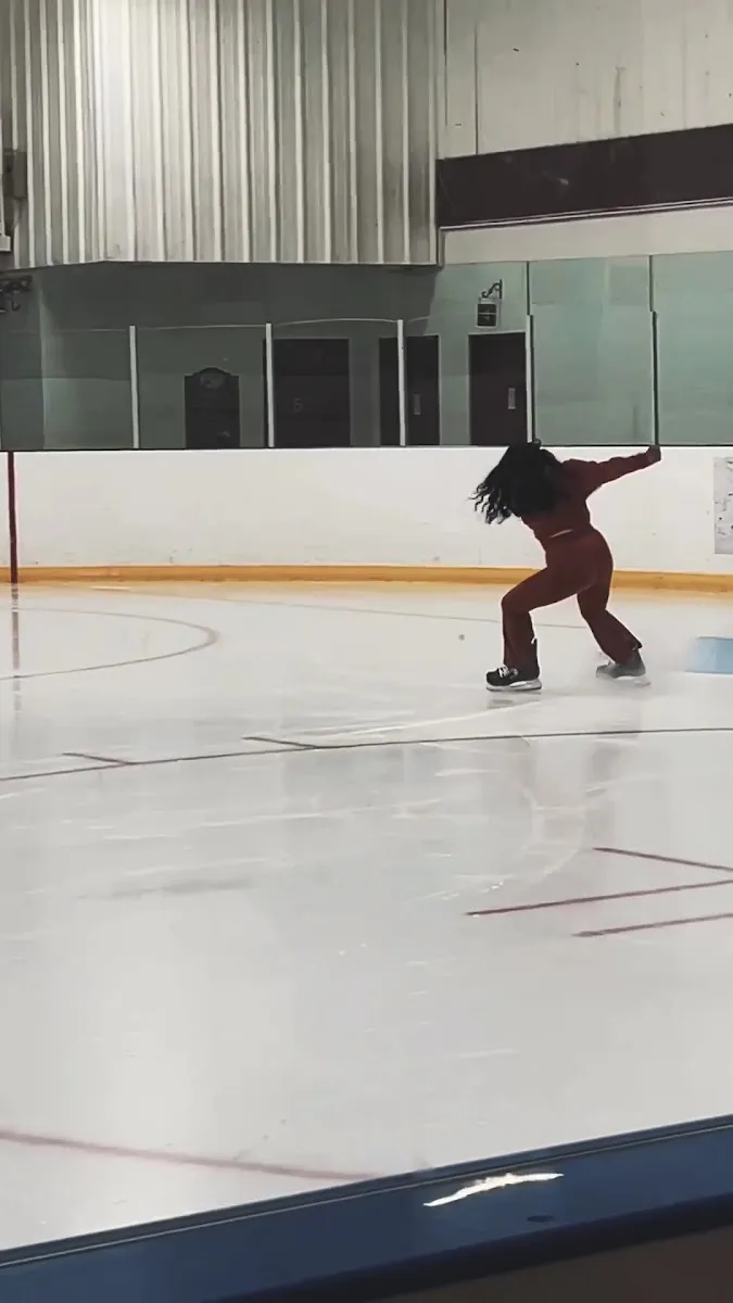 A lone skater practising on the Humphrey Arena ice with the boards and seating behind. — Humphrey Arena