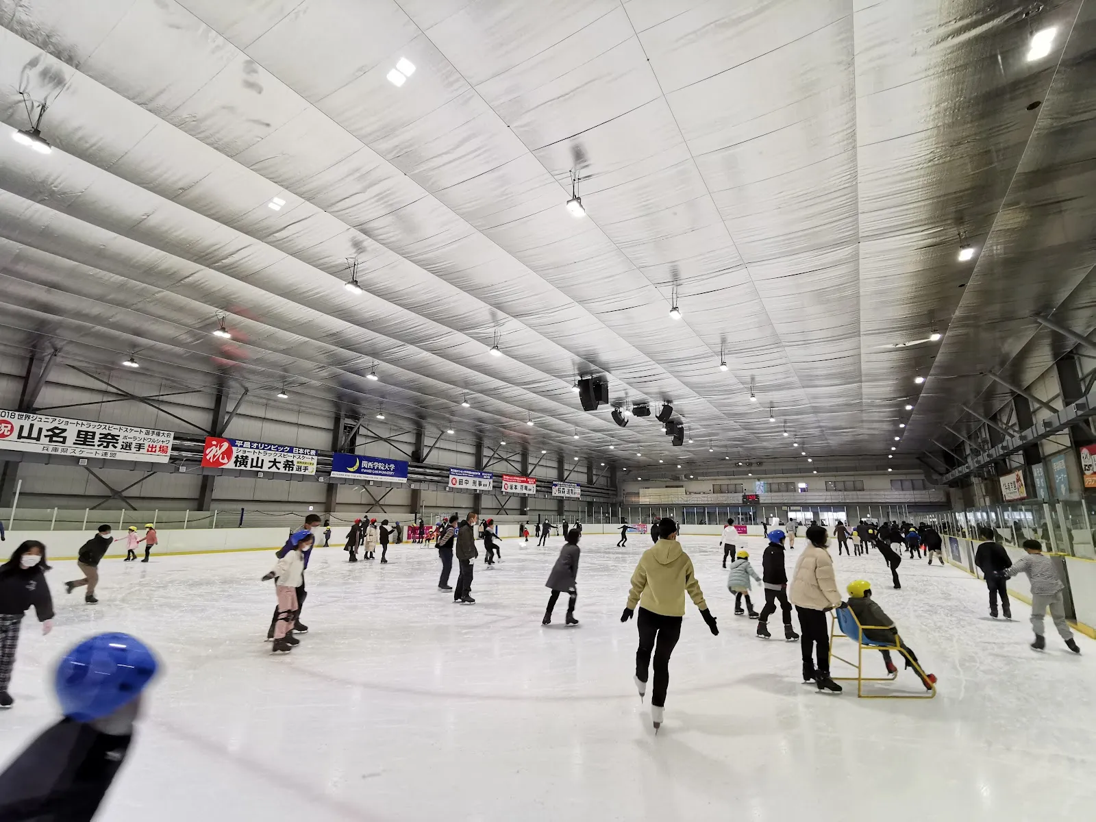 一般滑走中の、Hyogo Nishinomiya Ice Arenaのメインリンク。ホールの広い眺めで、滑走者が氷面に散らばっています — Hyogo Nishinomiya Ice Arena