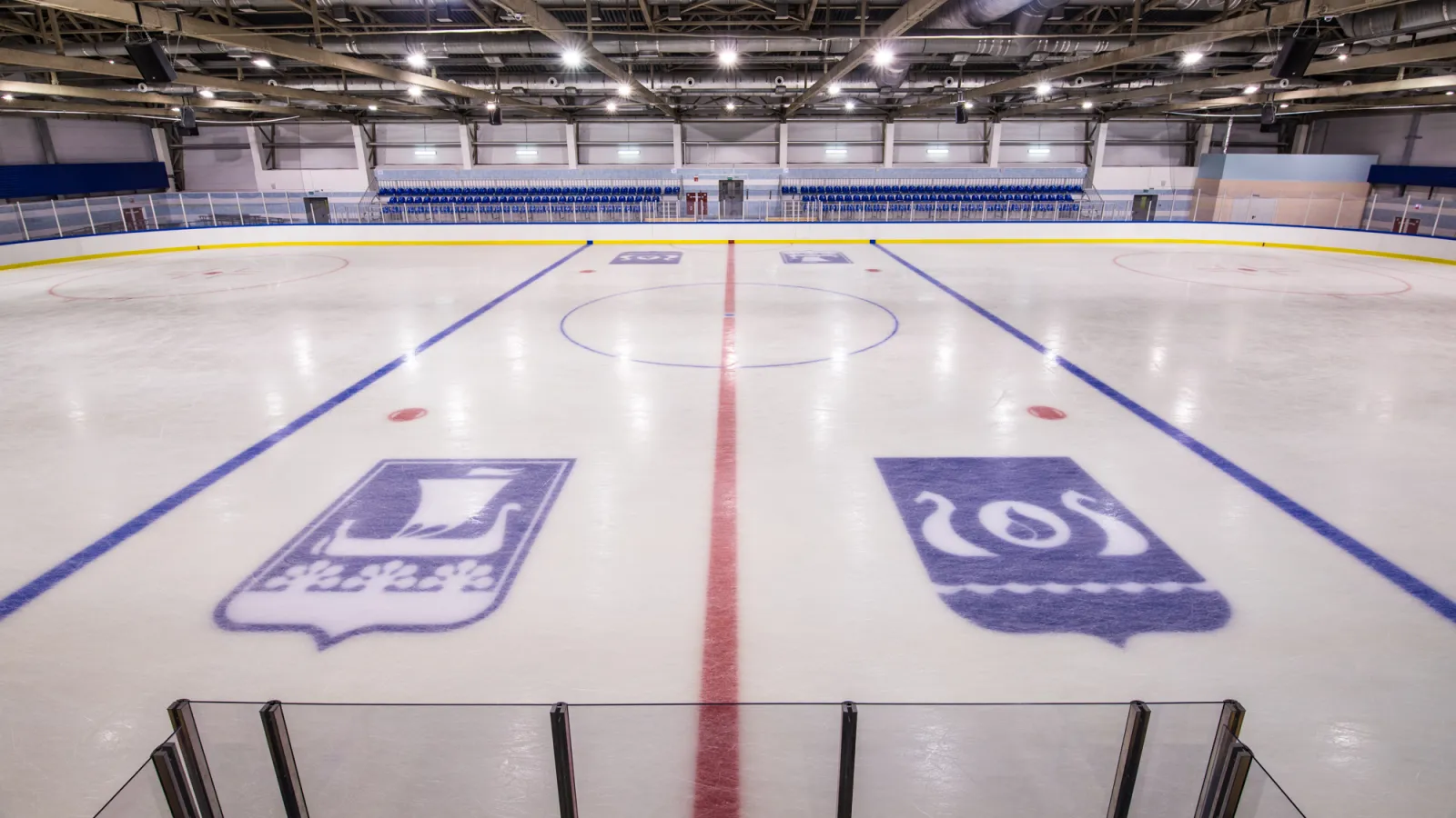 The ice of the Ice Arena Kirishi with the town emblems on the ice — Ice Arena Kirishi
