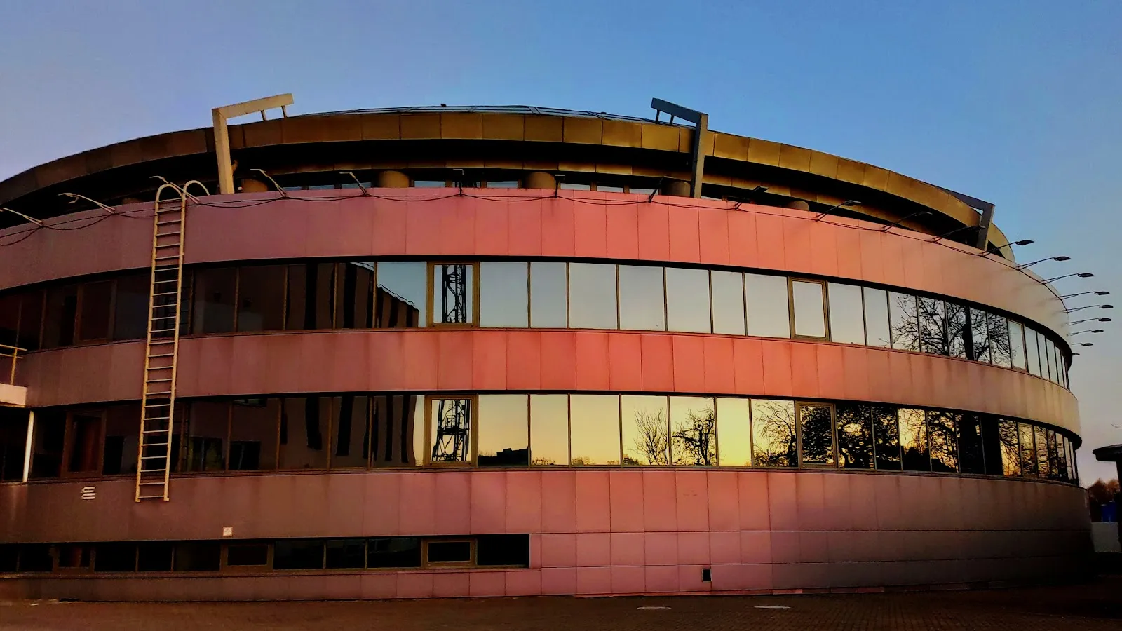 The curved facade of the PolesGU ice arena in Pinsk at dusk — PolesGU Ice Arena