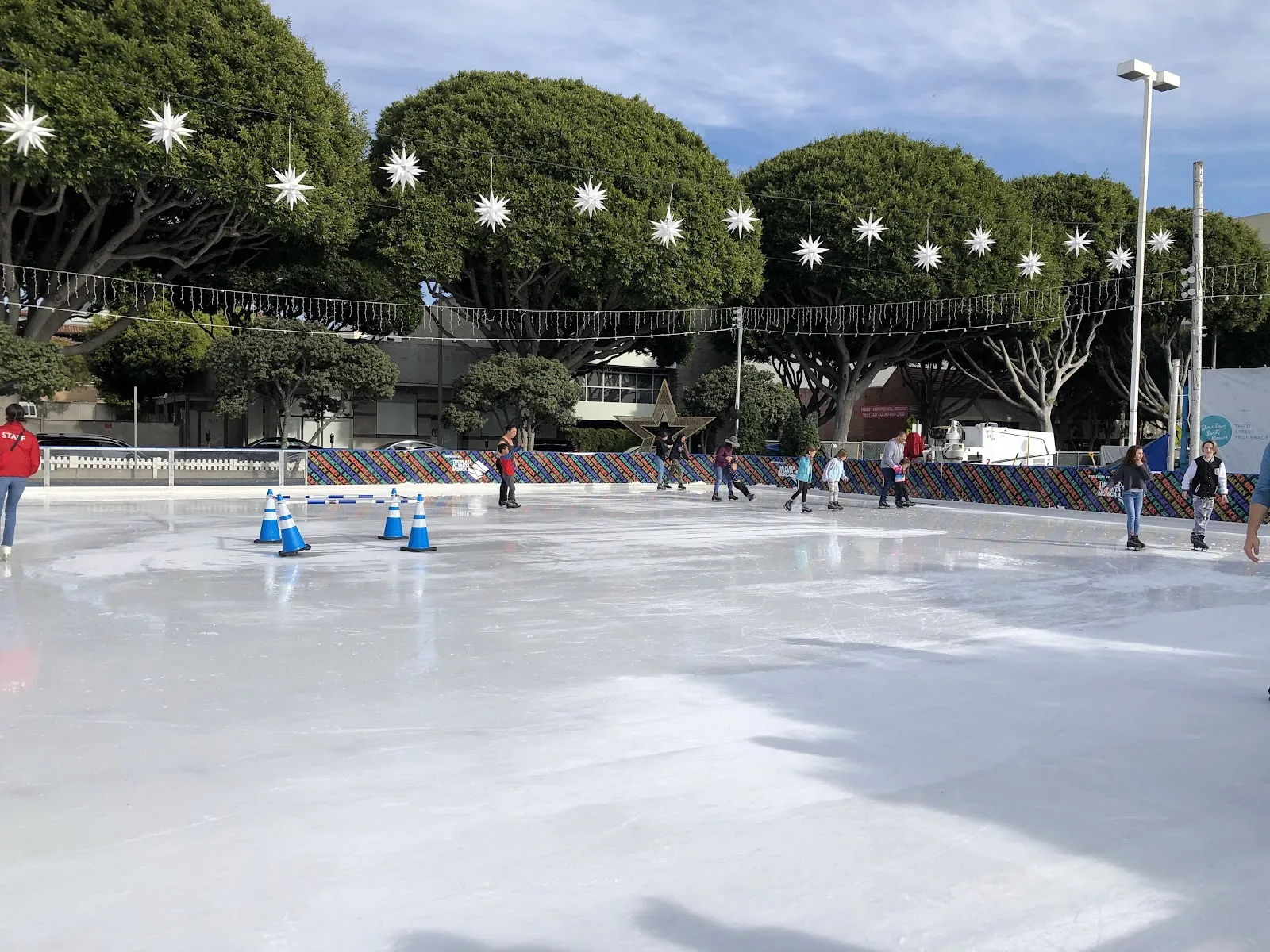 La superficie de la pista Ice at Santa Monica con adornos navideños en forma de estrella en el centro de Santa Monica (foto del listado de Google Maps) — Ice at Santa Monica