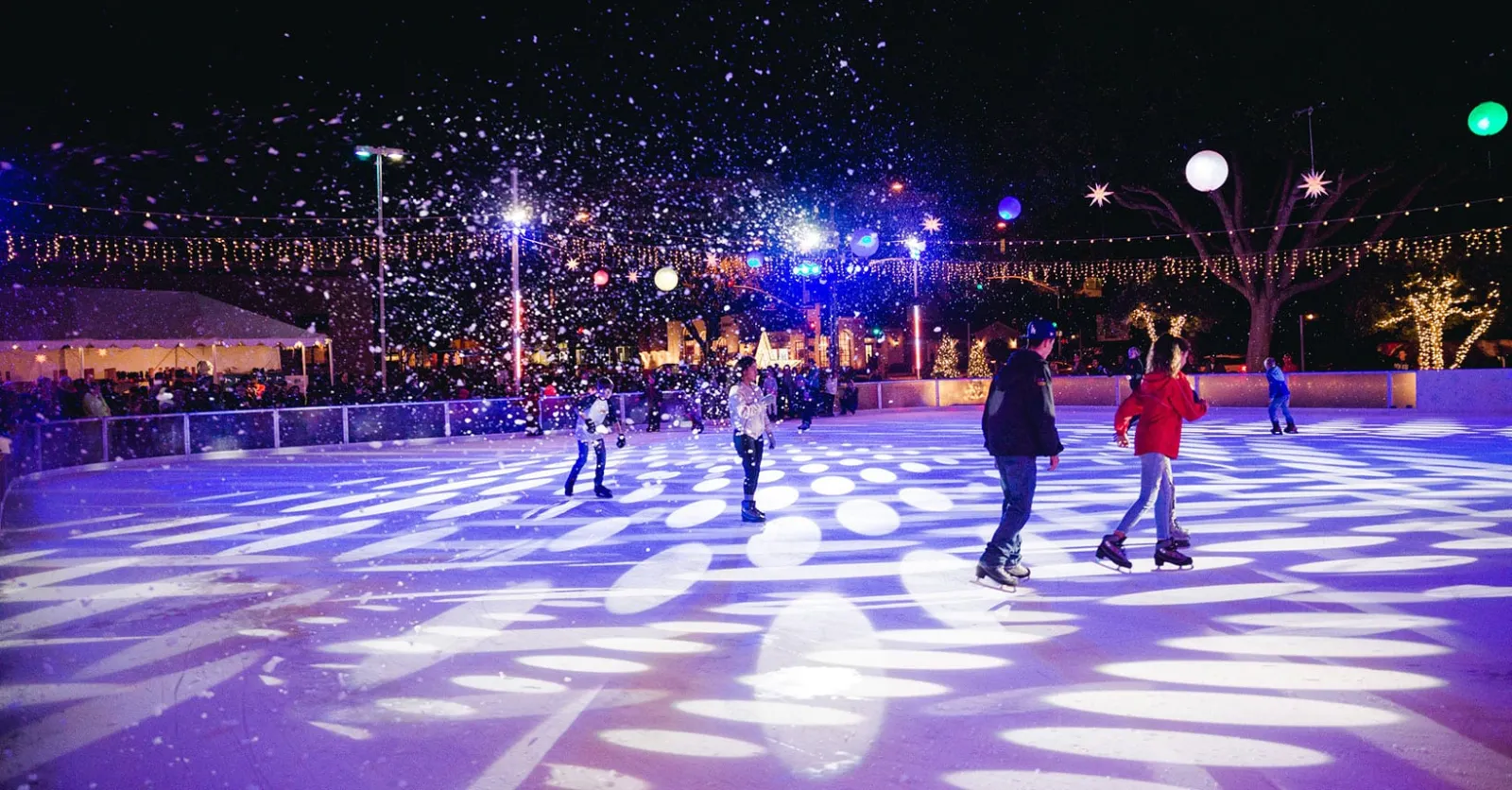 Patinadores en la pista Ice at Santa Monica bajo las luces de la noche (sitio web de Ice at Santa Monica) — Ice at Santa Monica