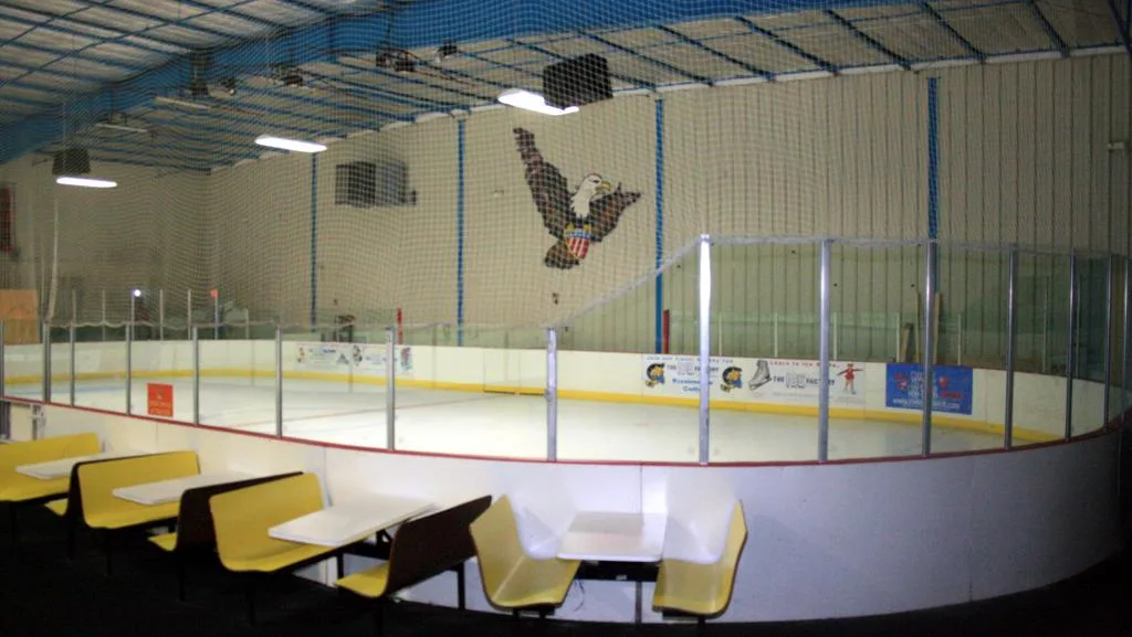 Smaller studio sheet seen over a row of yellow cafe booths outside the glass — The Ice Factory of Central Florida