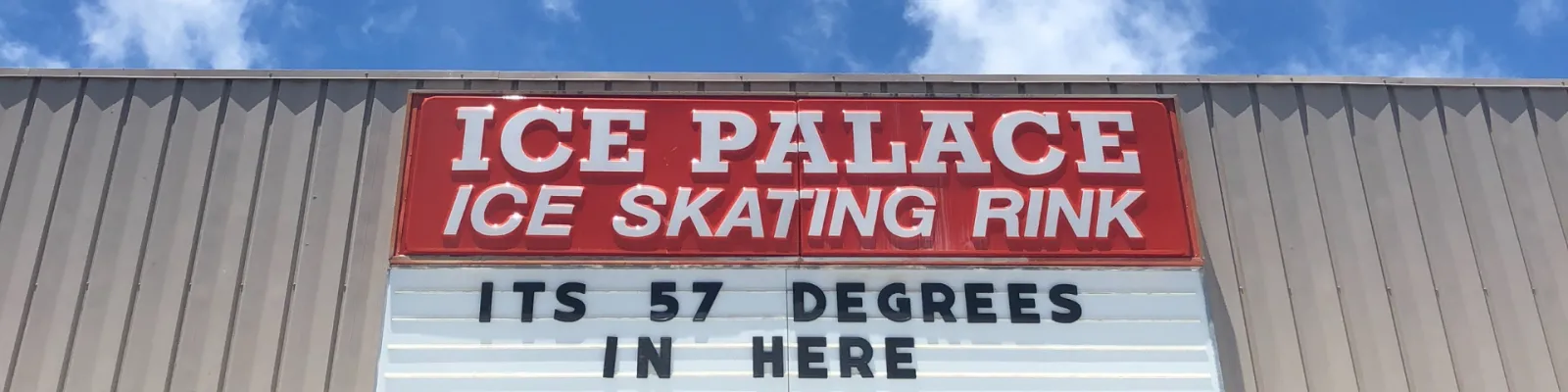 The building's red 'ICE PALACE ICE SKATING RINK' marquee sign against a blue sky, with a changeable message board reading the indoor temperature. — Ice Palace Hawaii