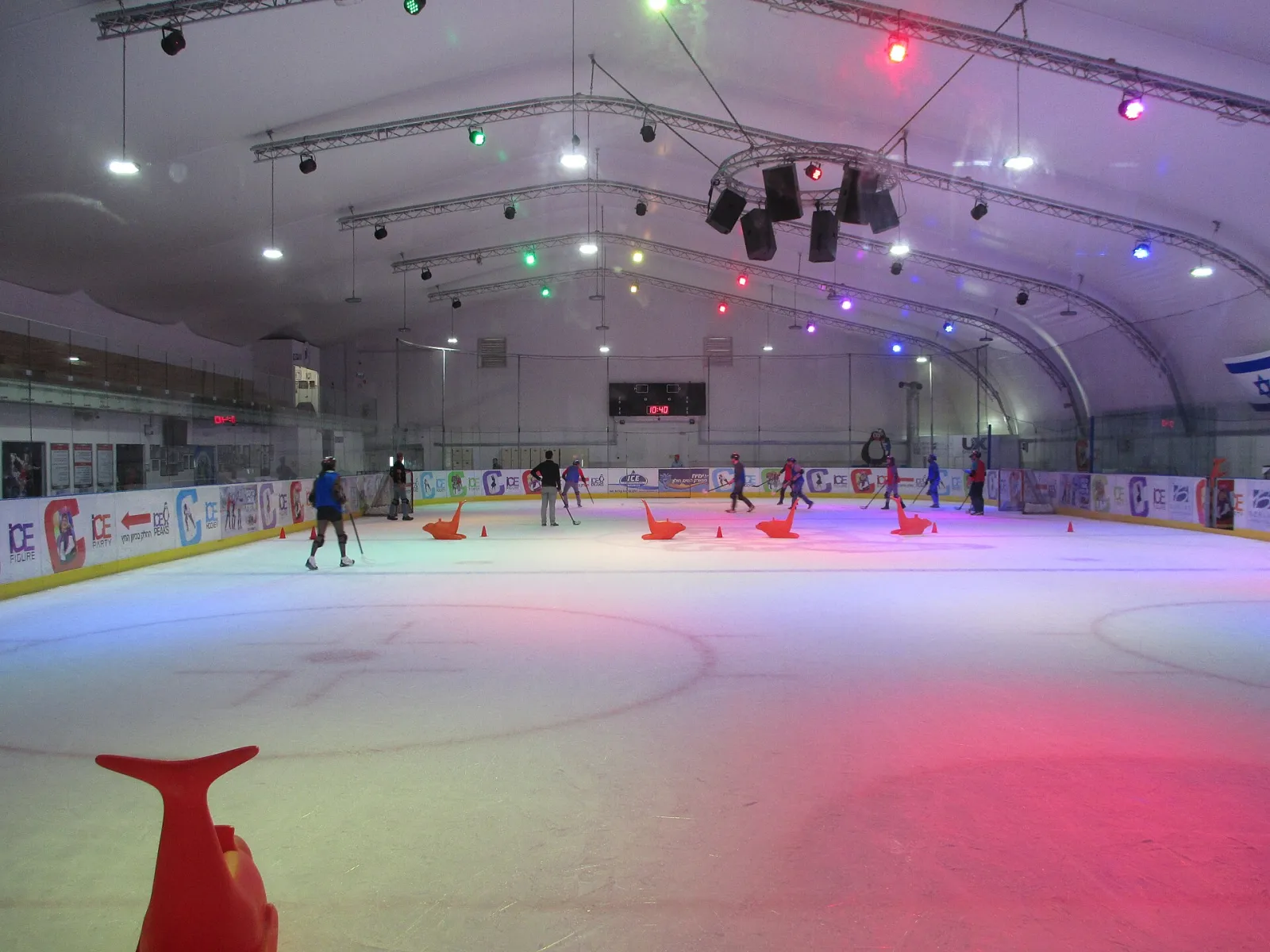 The ice sheet at Ice Peaks under the dome, with a few skaters at the far side — Ice Peaks Holon