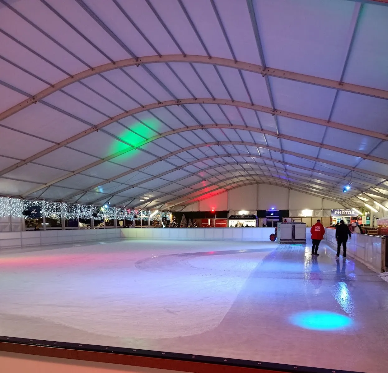 The empty ice of Ice Skating Blanchardstown under its curved marquee roof, with the photo booth at the far end — Ice Skating Blanchardstown