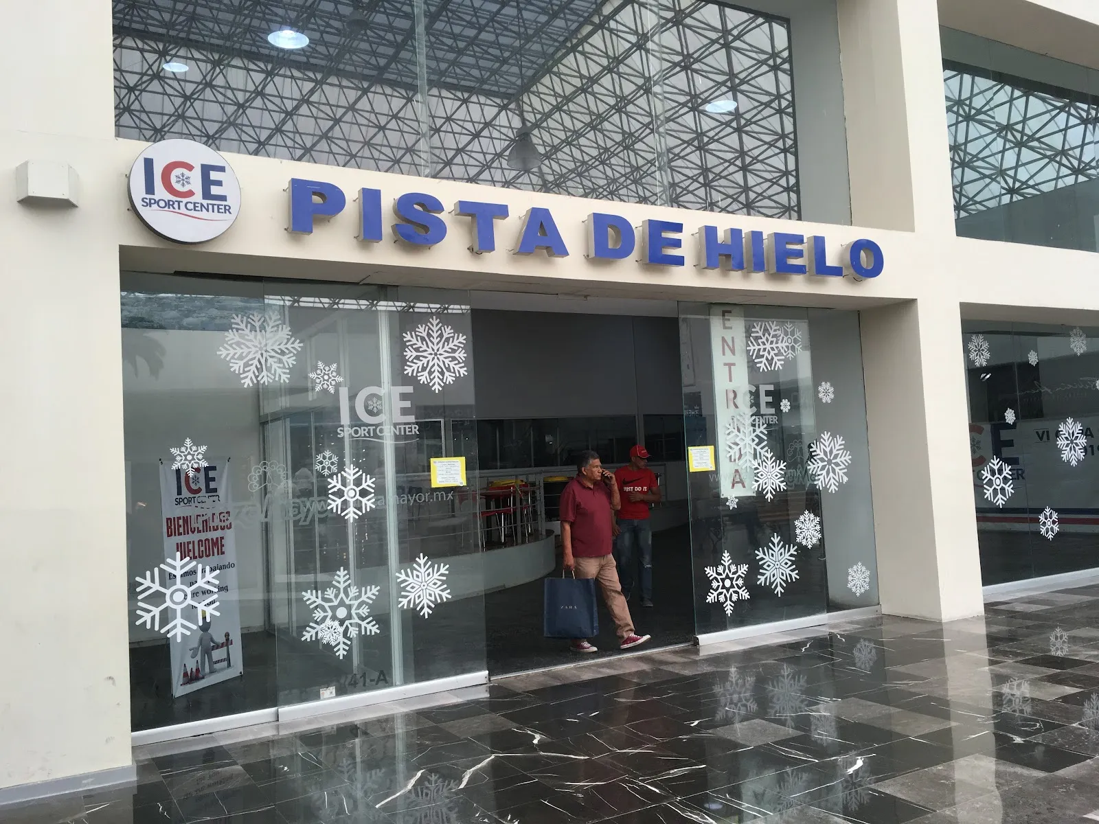 The Pista de Hielo entrance of Ice Sport Center in the Plaza Mayor mall in León, with the Ice Sport Center logo and snowflake decals on the glass doors — Ice Sport Center