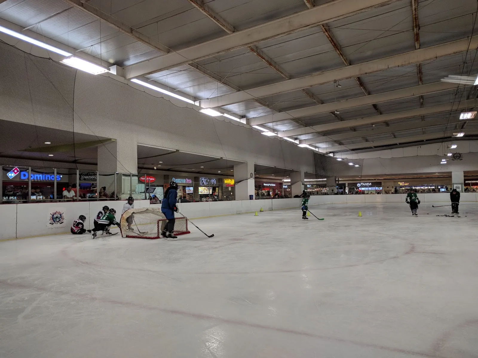 The Forum Buenavista rink during a youth hockey session, with the mall food court along the far side — Ice Station Buenavista