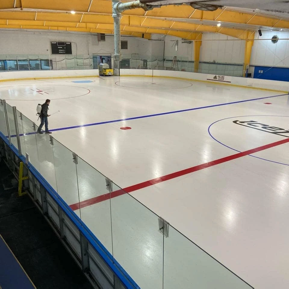 Una vista a través del hielo bajo las vigas amarillas del techo — Atlanta IceForum