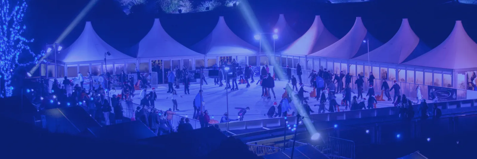 The Calverley Grounds rink and its pavilion tents seen from above, with skaters on the ice at night (the operator's photo) — Icescape Tunbridge Wells
