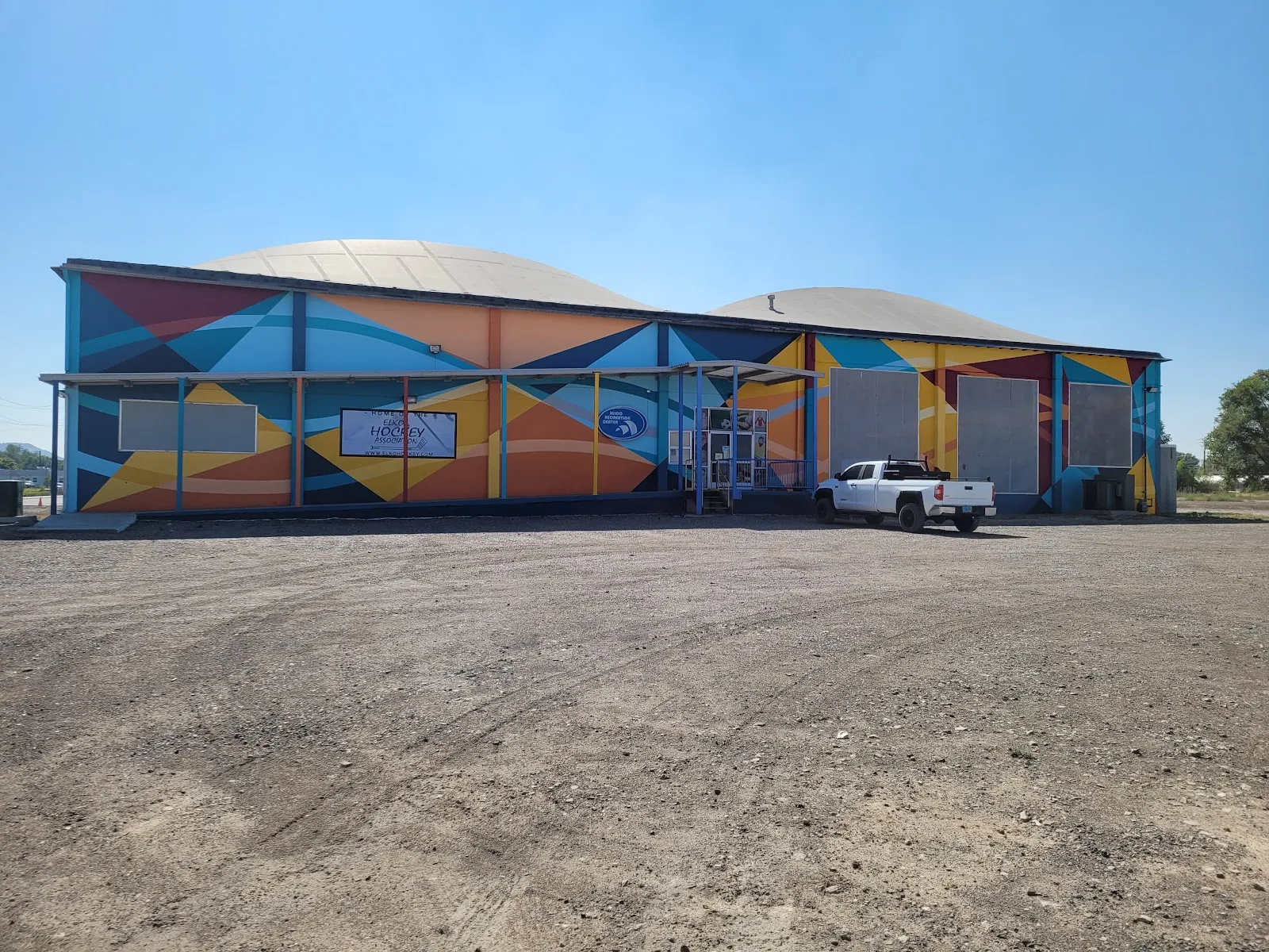 The Igloo recreation centre in Elko, a long building covered in a colourful mural, seen from the car park — Igloo Recreation Center