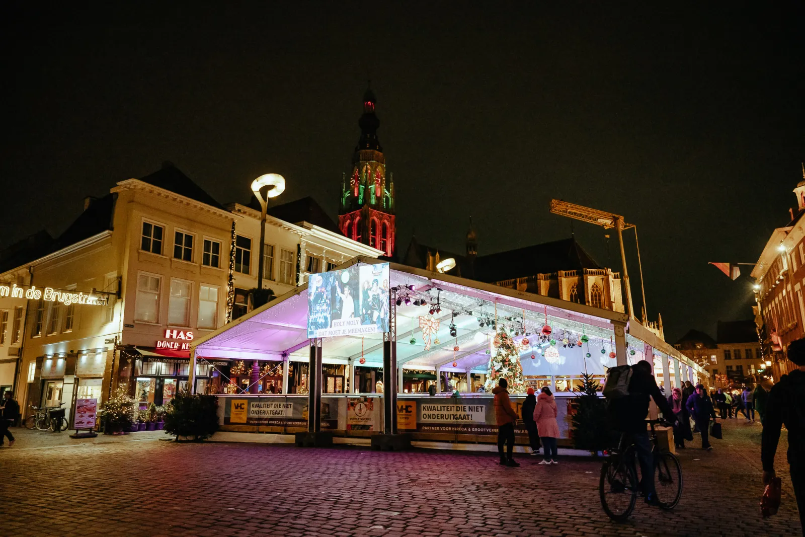 Het overdekte IJsplein op de Grote Markt in Breda ’s nachts, met de toren van de Grote Kerk erachter – IJsplein Breda