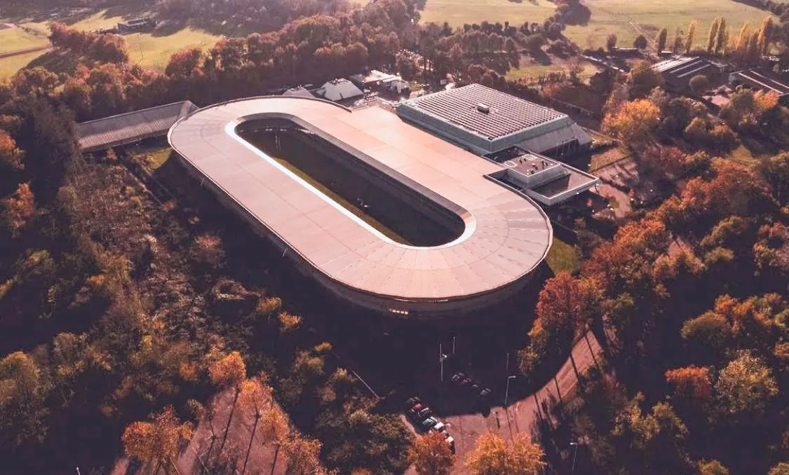 Luchtfoto van de half overdekte 400 m-baan en de hal van IJssportcentrum Eindhoven in de herfst – IJssportcentrum Eindhoven