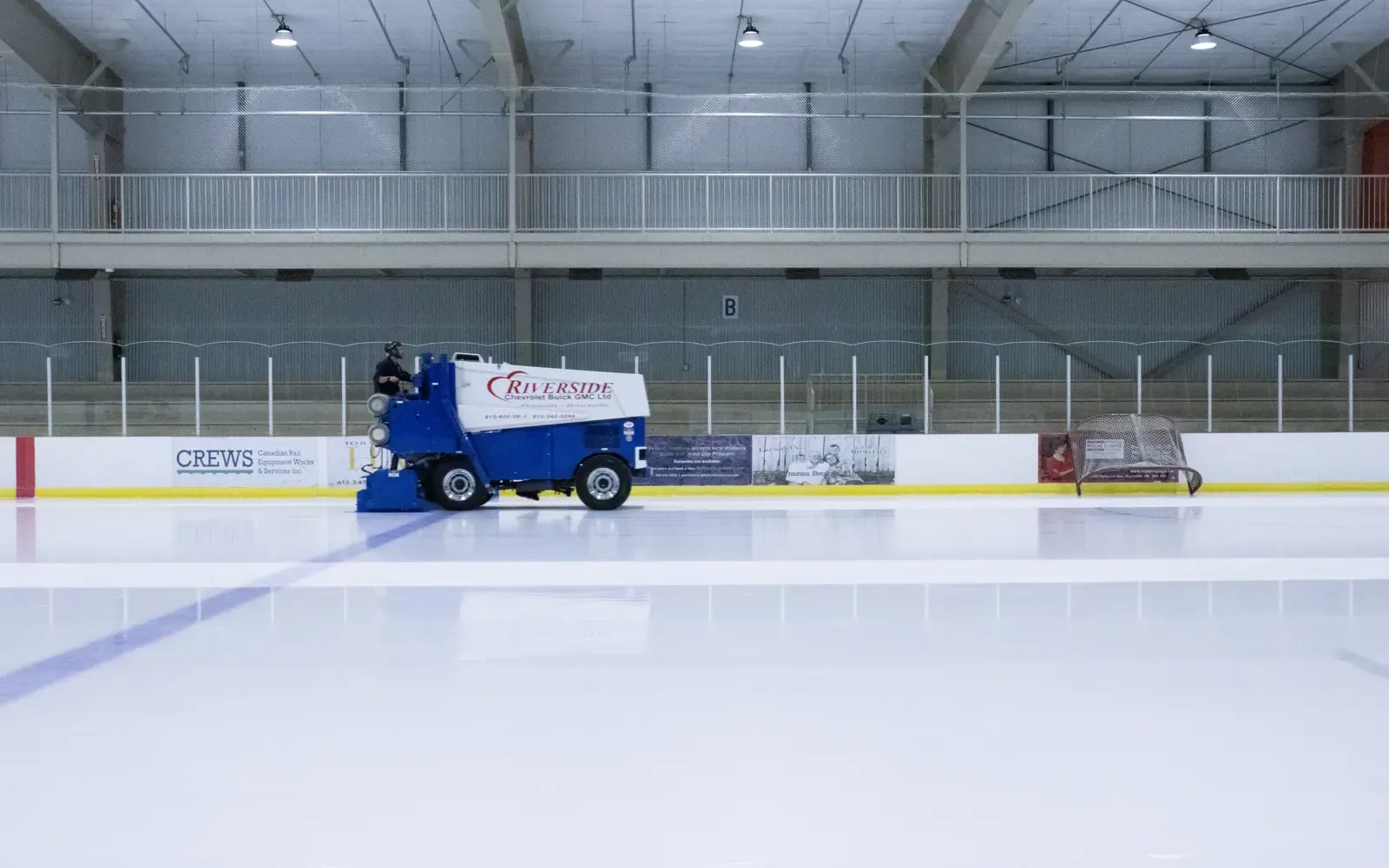 The Ingredion Centre ice in Cardinal with the resurfacer crossing it and the upstairs viewing gallery behind the glass. — Ingredion Centre (Cardinal)