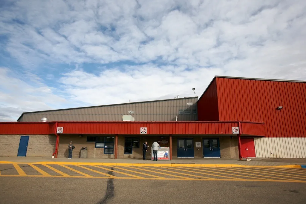 La fachada de la entrada, de techo rojo, de la Innisfail Twin Arena en 42 Street, en Innisfail, bajo un cielo parcialmente nublado — Innisfail Twin Arena