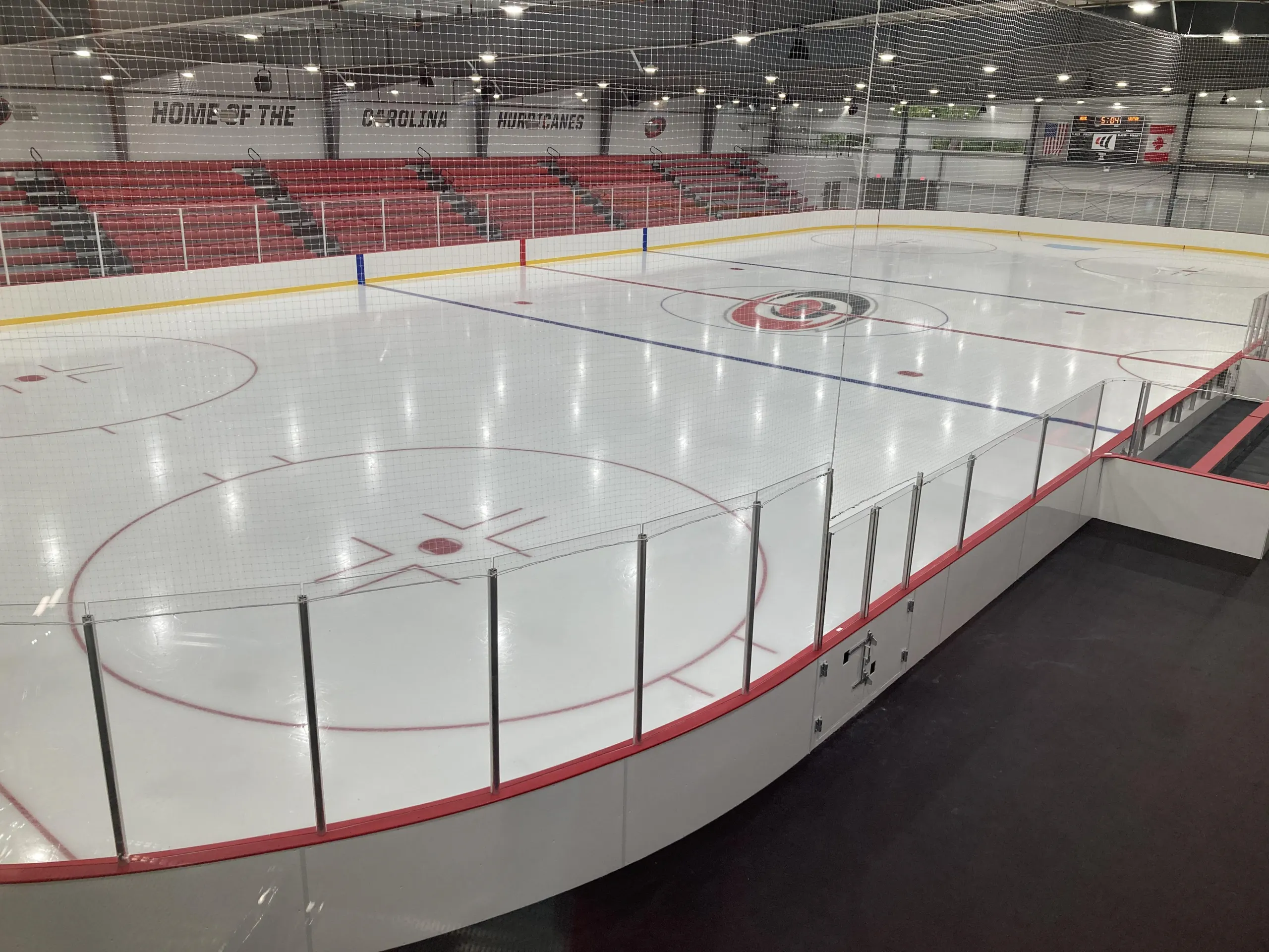 Hurricanes centre-ice logo below tiers of red seats — Invisalign Arena at Wake Competition Center