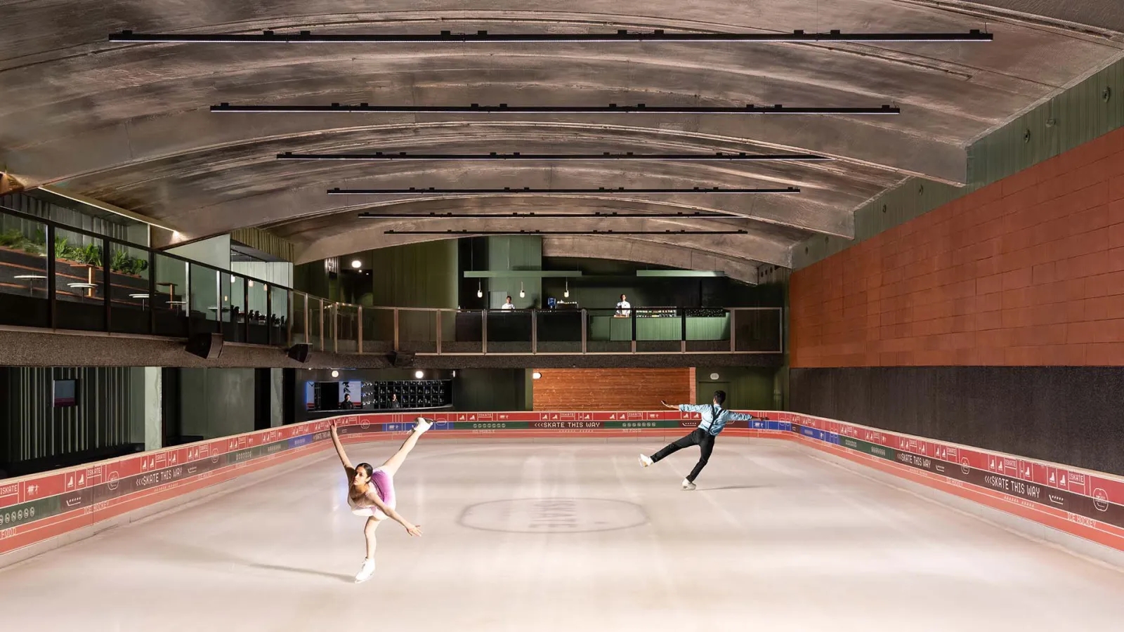 The full sheet of real ice at ISKATE, with its barrel-vaulted ceiling and the viewing gallery along the far side. — ISKATE by Roseate