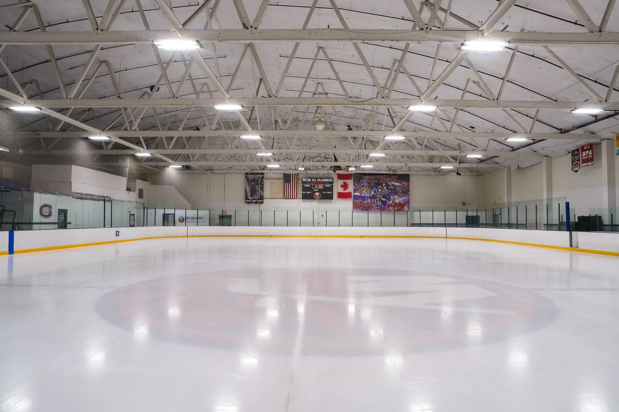 Whole sheet empty and freshly flooded, shot low from ice level — Islanders Iceworks