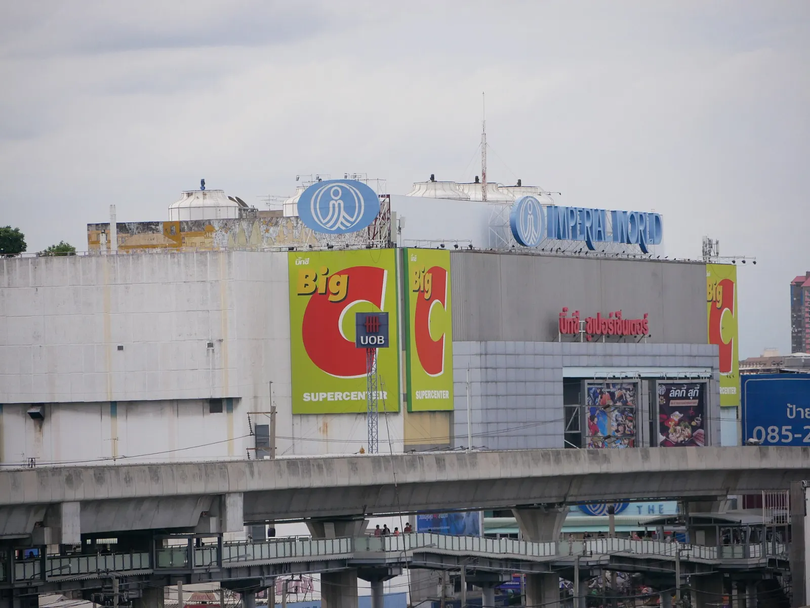The roof-level Imperial World sign of the Samrong complex seen from the BTS line, the building whose fifth floor holds the IWIS rink. — IWIS International Ice Skating Rink