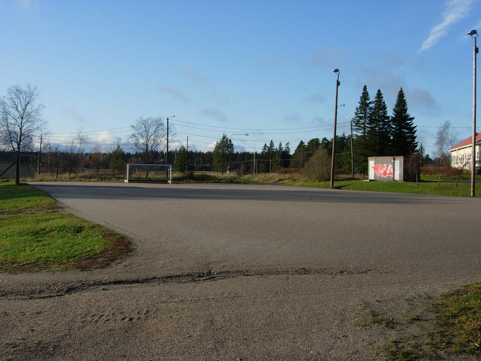 The gravel pitch at Jäkärlä with a football goal, which the city freezes into a skating field each winter, seen in summer. — Jäkärlän luistelukenttä