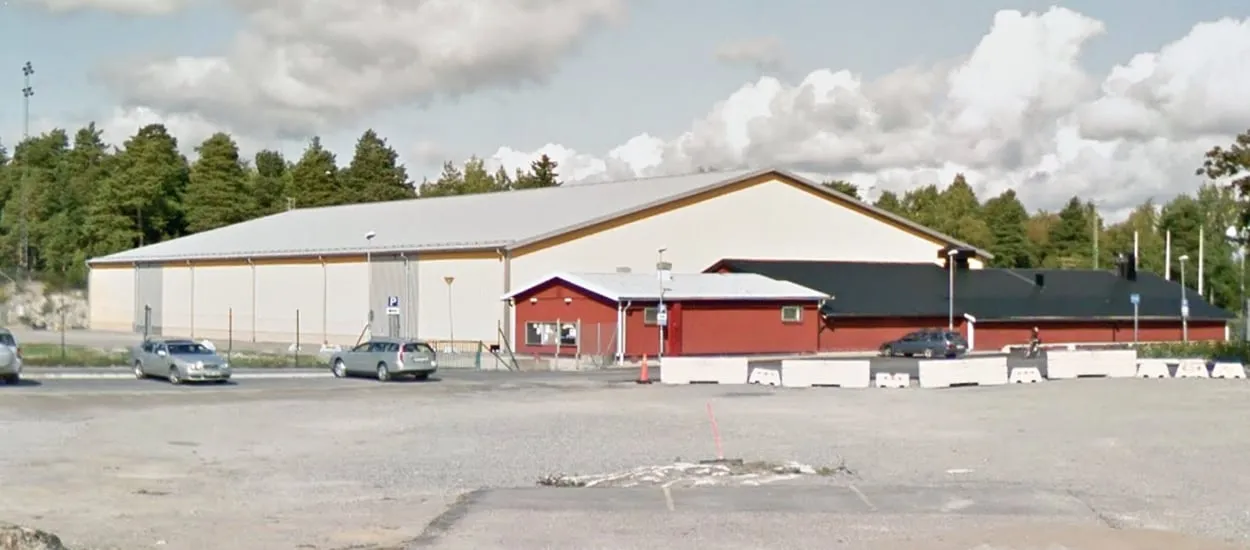 Byggnaden Järna IP ishall, tidigare Ljungbackens ishall, sedd över parkeringen – Järna IP ishall