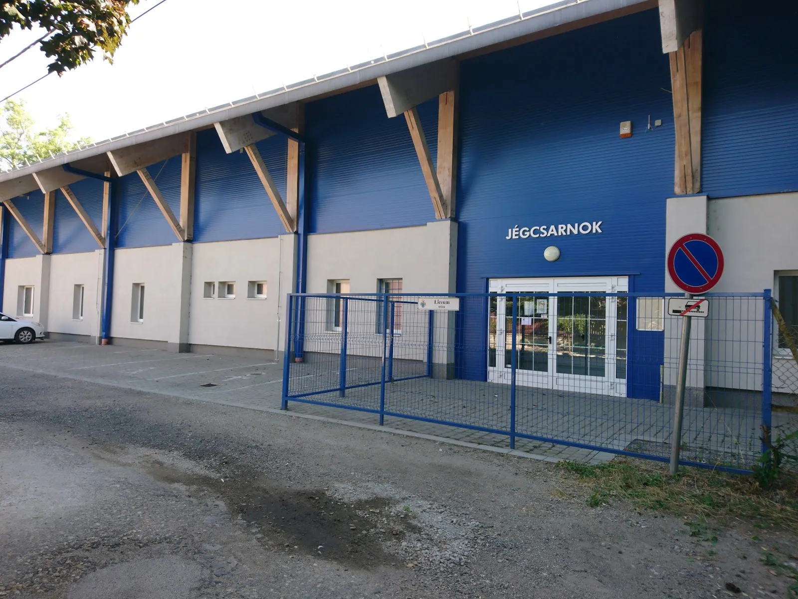 The blue-fronted entrance of the Jászberény ice hall (Jégcsarnok) with its sign over the doors — Jászberényi Jégcsarnok