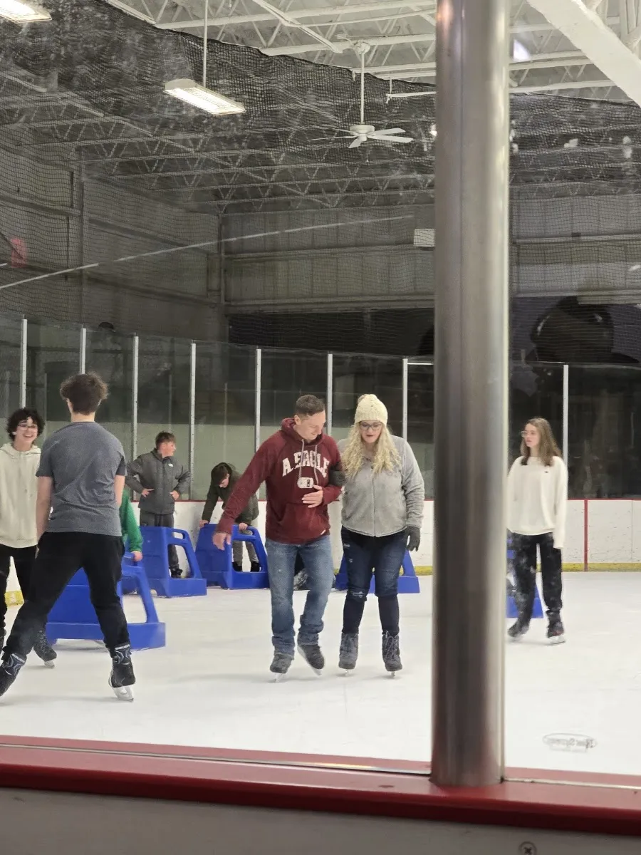 Public skating on the ice at the J.B. Chambers Memorial Rink, seen through the glass — J.B. Chambers Memorial Rink