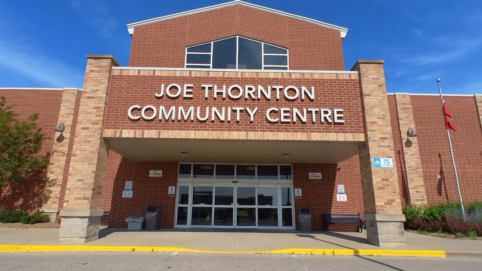 The brick front entrance of the Joe Thornton Community Centre on Caso Crossing in St. Thomas, under its name sign — Joe Thornton Community Centre