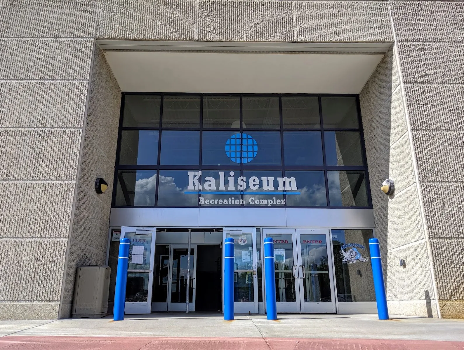 The stone-faced Kaliseum entrance with its name above the glass doors. — Kaliseum Recreation Complex